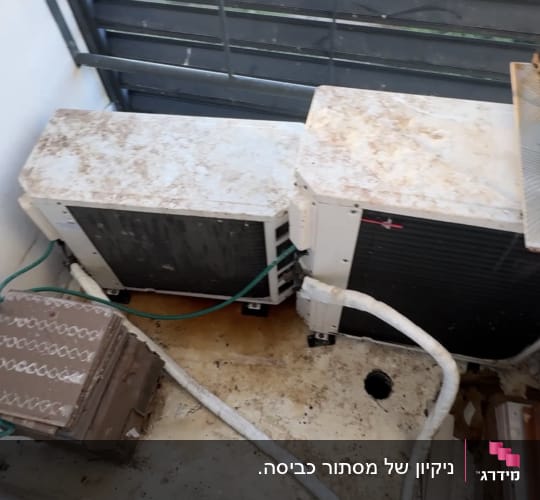 מסתור כביסה עם מעבי מזגנים המכוסים בצואת יונים לפני ניקוי